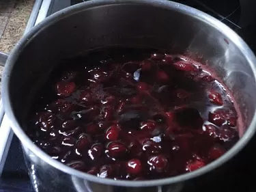 Прежде всего надо приготовить компоте. Для этого оставьте замороженную вишню при комнатной температуре. Слейте примерно 100 мл образовавшегося сока размешайте в нем крахмал. Вишню засыпьте сахаром и поставьте на огонь. Когда сахар растает и образовавшийся сироп закипит, поварите минуты три, затем добавьте разведенный крахмал, постоянно помешивая, доведите до кипения и уберите с огня. Оставьте остывать.