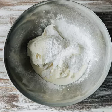 Фото шага рецепта №9 Готовим крем:Сливки 33% взбиваем с сахарной пудрой Dr. Bakers до устойчивых пиков. Творожный сыр (маскарпоне, рикотта) разминаем вилкой. Небольшими порциями перекладываем в сливки и взбиваем на средней скорости миксера до плотного воздушного крема.